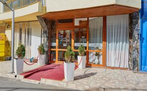 a store front with potted plants in front of it at Petar and Pavel Hotel & Relax Center in Pomorie