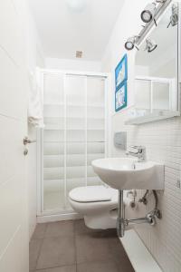 uma casa de banho branca com um WC e um lavatório em Vistas al Mar junto a la Playa 2D em Poris de Abona