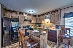 a kitchen with wooden cabinets and a island with chairs at Boating Mecca Near Dale Hollow Lake and Golf! in Frogue