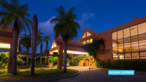 a building with palm trees in front of it at Vila Galé Eco Resort do Cabo - All Inclusive in Cabo de Santo Agostinho