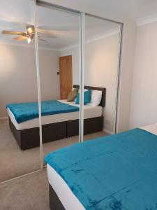 a bedroom with two beds and a mirror at Centrally Located accommodation near town center in Kent