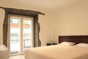 sypialnia z łóżkiem i dużym oknem w obiekcie Faial Marina Apartments 2 w mieście Horta