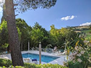 une piscine dans un jardin avec un arbre dans l'établissement Italian Experience-Villa Millefiori, à Porto San Giorgio