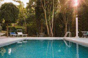 - une piscine avec 2 chaises et une table dans l'établissement Italian Experience-Villa Millefiori, à Porto San Giorgio