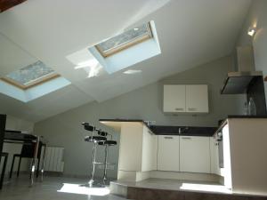 a kitchen with white cabinets and skylights in the ceiling at Le Gîte de L'Ours in Saint-Ours