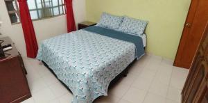 ein Bett mit blauer Decke in einem Schlafzimmer in der Unterkunft Casa de Descanso Marrón 101 in Villavicencio