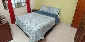 a bed with a blue comforter in a bedroom at Casa de Descanso Marrón 101 in Villavicencio