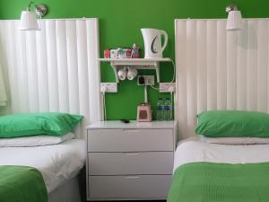 ブラックプールにあるOakleigh Houseの緑の壁のベッドルーム1室(ベッド2台付)
