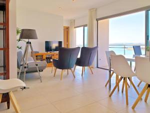 uma sala de estar com cadeiras, uma mesa e uma televisão em Cofradia Penthouse em Alcudia