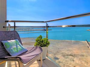 a chair on a balcony with a view of the ocean at Cofradia Penthouse in Alcudia
