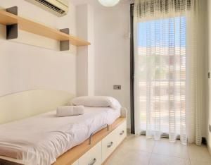 a bedroom with a bed and a large window at Cofradia Penthouse in Alcudia