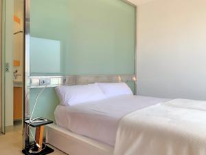 a bedroom with a white bed and a mirror at Cofradia Penthouse in Alcudia