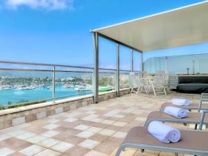 a balcony with chairs and a view of the water at Cofradia Penthouse in Alcudia