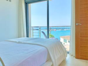 a bedroom with a bed and a view of the ocean at Cofradia Penthouse in Alcudia