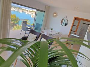 a room with a table and chairs and a view of the water at Cofradia Penthouse in Alcudia