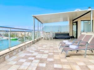 a balcony with chairs and a view of the water at Cofradia Penthouse in Alcudia