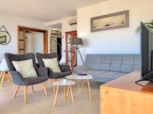 a living room with a couch and chairs and a tv at Cofradia Penthouse in Alcudia