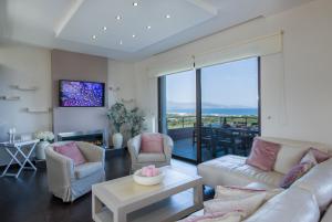 a living room with a couch and chairs and a table at Villa Elisabeth View in Platanias