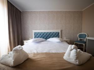 1 dormitorio con 1 cama con toallas en Pensiunea RYN en Sebeş