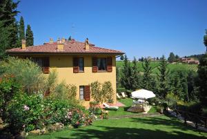 a large yellow house with a garden and trees at Tenuta la Cipresseta in Monsanto
