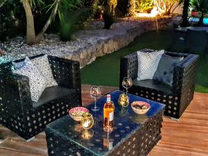 a table with two chairs and two bottles and glasses at La Villa Blanche in Sanary-sur-Mer