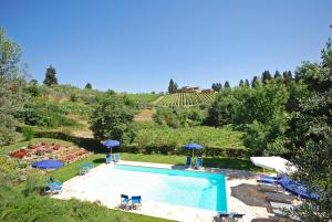 an outdoor swimming pool with umbrellas and chairs at Tenuta la Cipresseta in Monsanto