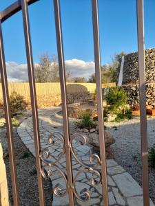 ein Tor zu einem Garten mit einem Steinzaun in der Unterkunft Trullo "Il fico d'india" in Alliste