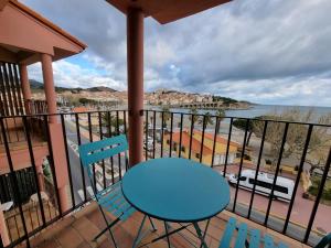 a table and chairs on a balcony with a view of the ocean at Appartement VUE MER TERRASSE CLIM WIFI in Banyuls-sur-Mer