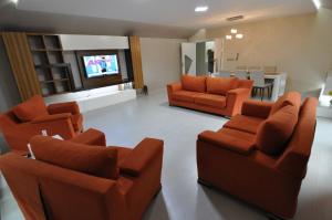 a living room with orange chairs and a dining room at Dekar Apartments in Trabzon