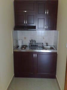 una cocina con armarios de color marrón oscuro y fregadero en Villa Ana, en Gornja Trepča