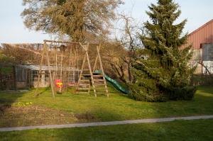 un parque infantil en un patio con un árbol en Chambres d'hôtes de la Quairelle en Gerpinnes