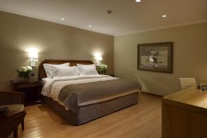 a bedroom with a large bed with two tables and two lamps at Windsor Hotel in Córdoba