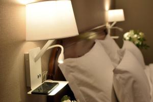 a lamp on a wall next to a bed at Windsor Hotel in Córdoba