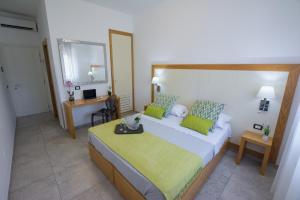 a bedroom with a large bed with green pillows at Best Western Hotel Martello in Lampedusa