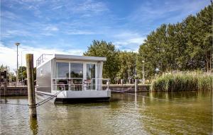 una pequeña casa en un barco en un río en Gorgeous Ship In Biddinghuizen With Wifi, en Biddinghuizen