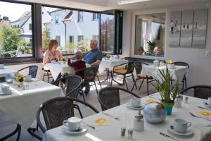 a man and woman sitting at a table in a restaurant at Hotel Bella Vista in Konstanz