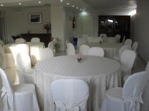 Hotel Giardino San Michele في فالو ديلا لوكانيا: غرفة مليئة بالطاولات والكراسي مع قماش الطاولة البيضاء