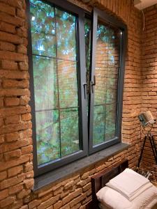 a window in a brick wall with a bench in front at Indigo Centar in Zagreb