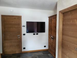 Habitación con 2 puertas y TV en la pared en Appartamento Divina, en Valdisotto