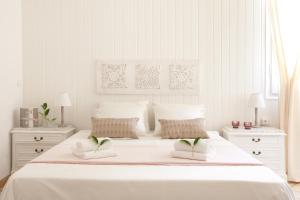 a white bedroom with a large white bed with two night stands at Casa Muntaner in Barcelona