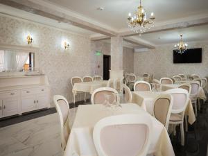Pensiunea RYN في سيبس: غرفة طعام مع طاولات بيضاء وكراسي بيضاء