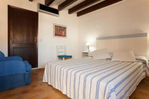 カラ・デ・サント・ビセントにあるAncora 1のベッドルーム1室(ベッド1台、青い椅子付)