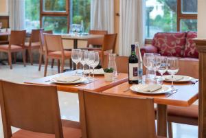 uma mesa com copos e uma garrafa de vinho em Hospedium Hotel Blu Sondika em Sondika