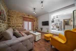 - un salon avec un canapé, des chaises et un mur en briques dans l'établissement GRANDMA´S HOUSE, à Stankovci