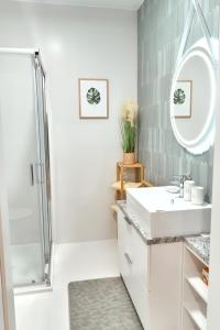 a white bathroom with a sink and a shower at LAGUNA Apartament "W CHMURACH" Wille Parkowe z klimatyzacją in Polanica-Zdrój