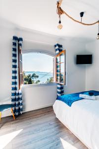 a bedroom with a bed and a large window at La Maison Fratelli in Hyères