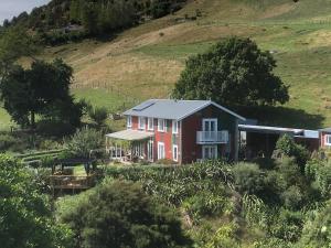 una casa rossa in un campo con una collina di The Pear Orchard Lodge a Richmond