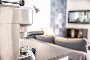 a coffee machine on a counter in a living room at Appartement à quelques pas de la mer WIFI CLIM PARKING in La Grande-Motte