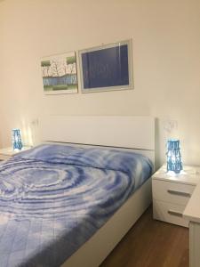 een bed met een blauw dekbed in een slaapkamer bij Casale Antico Borgo in Colico