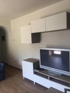 een woonkamer met een flatscreen-tv op een kast bij Casale Antico Borgo in Colico